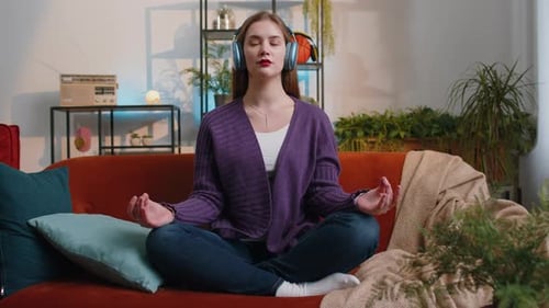 Young Woman Meditating at Home with Headphones