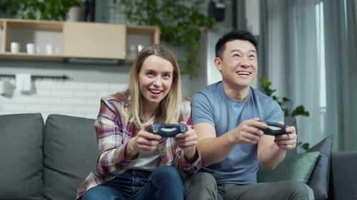 Happy Couple Playing Video Games on Sofa