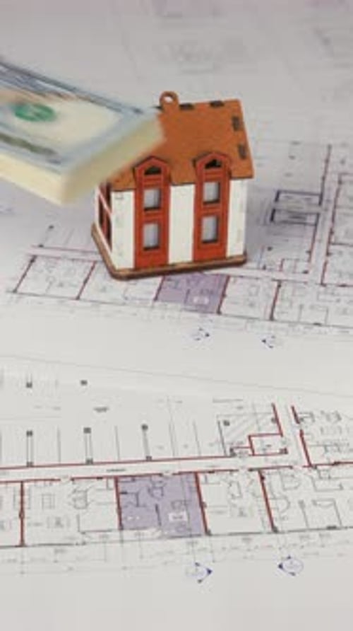Miniature House and Money on Building Plans