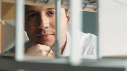 Focused Man Examining Architectural Model at Workplace