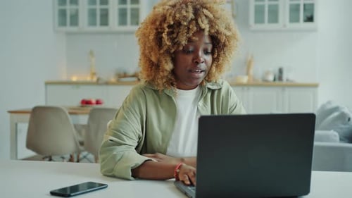 Young Black Woman Speaking via Video Call on Laptop at Home
