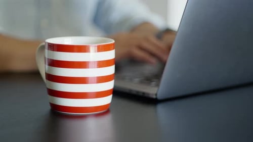 Morgenkaffee trinken, während Sie von zu Hause aus mit Laptop arbeiten