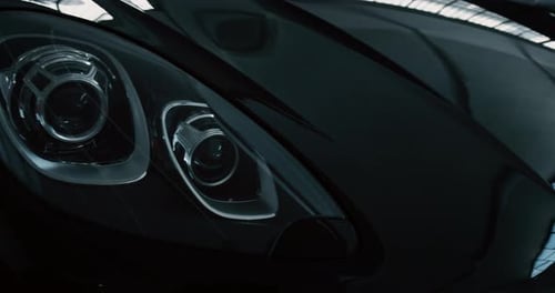 Close up of details of switched on headlights of anonymous prestigious luxury modern car. Shot in