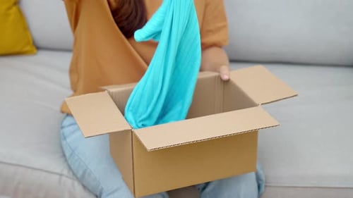Woman Unboxing a Bright Blue Shirt at Home