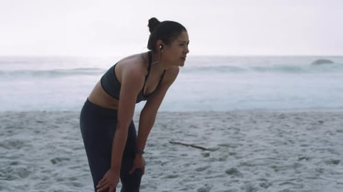 Tired, fitness and woman after sports, running and beach workout training in the morning