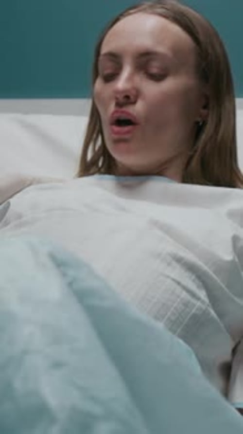 Vertical de una mujer embarazada que empuja mientras da a luz a un bebé