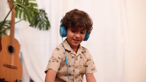Boy Listening with Headphones to Music Indoors