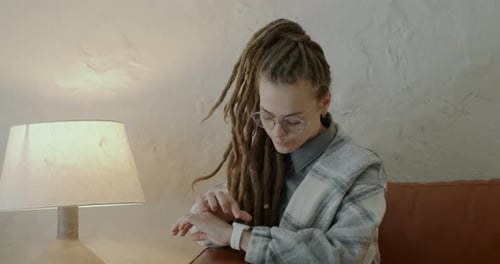 Woman Using Smart Watch While Sitting Indoors