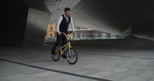 Man Performing Tricks on Yellow BMX Bike in City