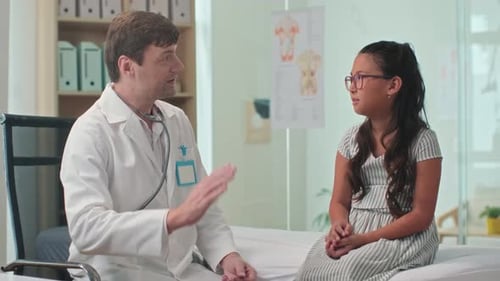 Medical Worker Cheering up Teenage Girl during Annual Check-up at Clinic