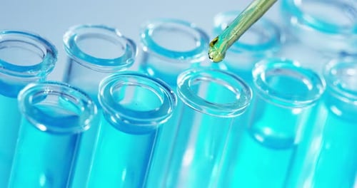 Dans un laboratoire, un scientifique muni d'une pipette analyse un liquide coloré pour en extraire l'ADN et la molécule