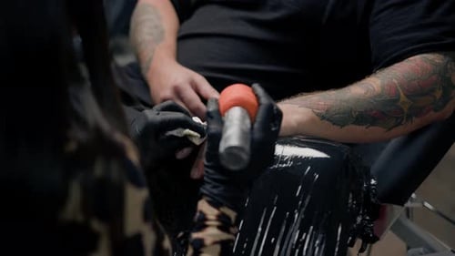 Close-up - a needle penetrates the skin, tattoo, tattoo studio