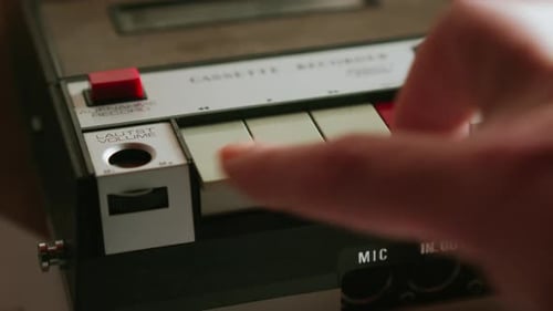 Close up of pressing buttons on vintage analog cassette recorder