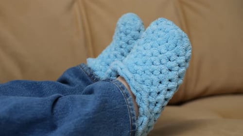 Person resting with hand-made wool socks on couch