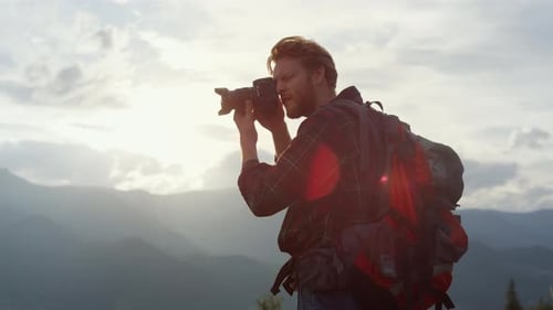 Jeune randonneur capturant un panorama de montagne