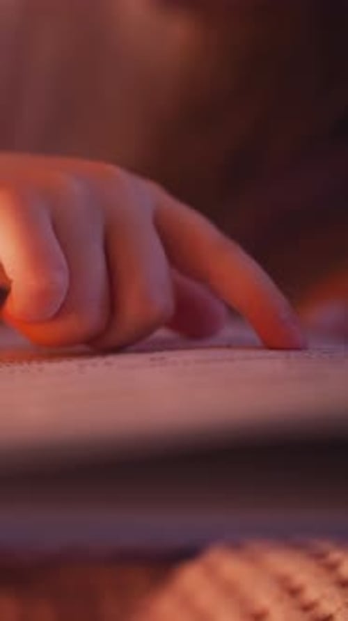 Hand of Kid Follows Line with Finger While Girl Reads Book