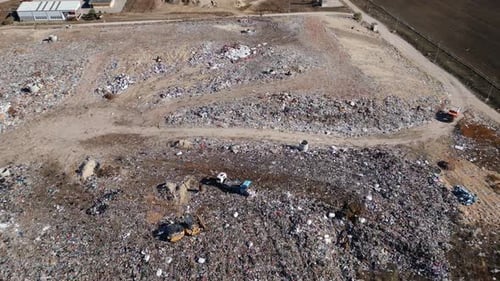 Aerial View of a Vast Landfill Where Bulldozers are Working and Trucks are Bringing New Waste Huge