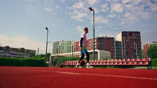 a Tall guy basketball player with the ball shows his dribbling skills during practice on the court