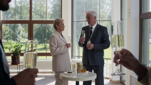 Diversos empresários falando e tilintando óculos em uma pequena festa