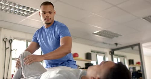 Physical Therapist Massaging Patient's Leg in Clinic