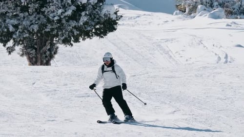 Skier Going Down a Snowy Mountain on a Sunny Winter Day