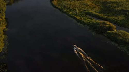 A Motorboat with Fishermen Sails Down the River on an Autumn Morning