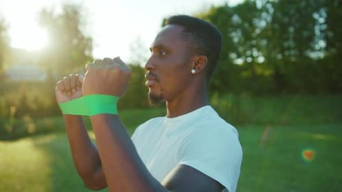 Healthylooking African American Athlete Doing Physical Activity in the Park Stretching Elastic Bands