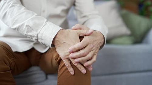 Senior Man Rubbing his Knee Close Up