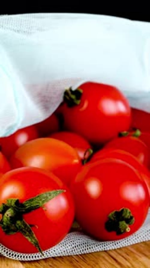 Pile Juicy Fresh Cherry Tomatoes in Ecofriendly Mesh Bag Rotates Smoothly