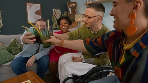 Wheelchair Users Clinking Lemonade Glasses with Diverse Friends at Home