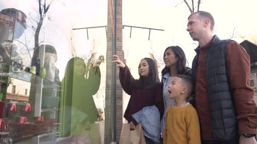 Family enjoying window shopping together in a canadian city slow motion