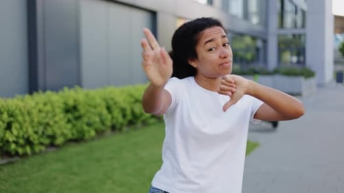 Woman Giving Thumbs Up and Thumbs Down