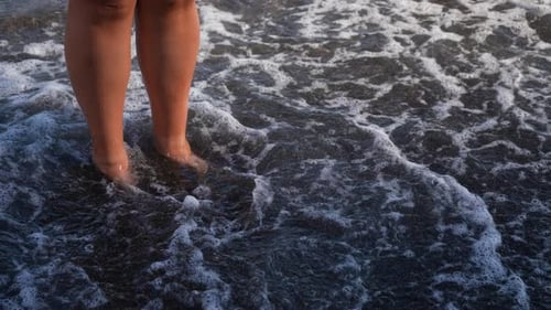 Closeup Cropped Shot Legs of Unrecognizable Woman Walking Along Wave of Sea Water and Sand on Summer