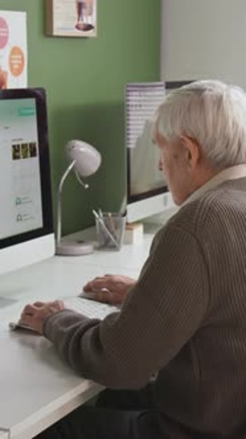 Vertical Shot of Senior Man Using Computer in Library