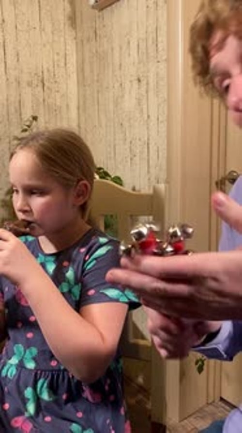 Girl Plays Wooden Flute with Family
