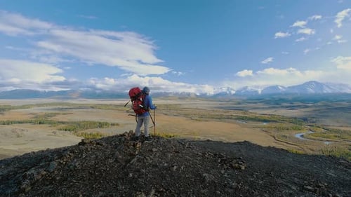 Wanderer mit Rucksack schaut Bergmännchen mit Tasche auf Wild Journey Climb Trek