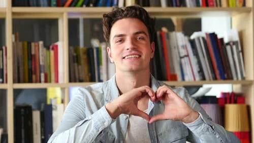 Young Man Makes Heart Shape with Hands
