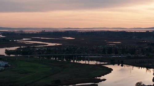 Drone aerial view of a highway heading in and out of Napa, California at sunset