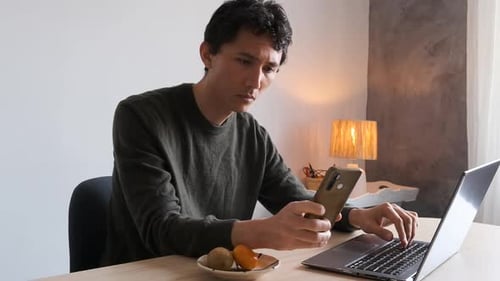 Young Adult Works on Laptop at Home