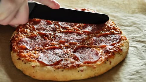 Cutting a Delicious Pepperoni Pizza with Knife