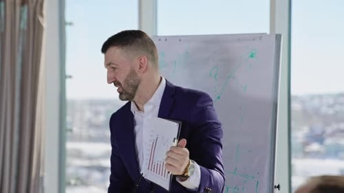 Man Explains Chart to Coworkers During a Meeting