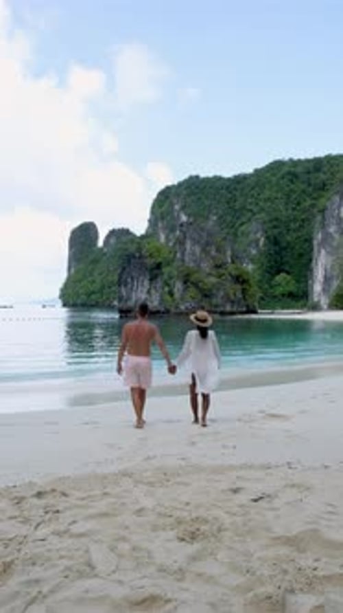Couple Strolls Hand in Hand Along the Serene Beaches of Koh Hong Islands in Krabi Thailand