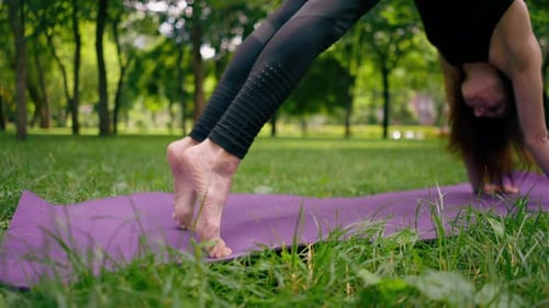 close-up athletic skinny pumped up legs of a woman standing with her feet on a mat for yoga