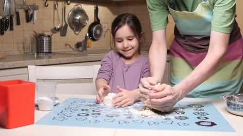 Mother and Daughter Kneading Dough Making Cookies in the Kitchen