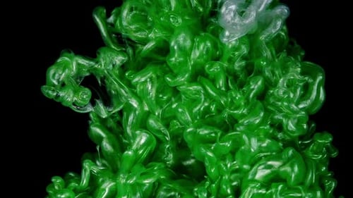 Emerald Elixir Green Ink Dissolves and Swirls Forming an Enchanting Underwater Display on a Black