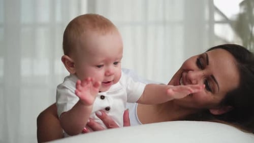 Loving Mother and Infant Laughing Together Indoors