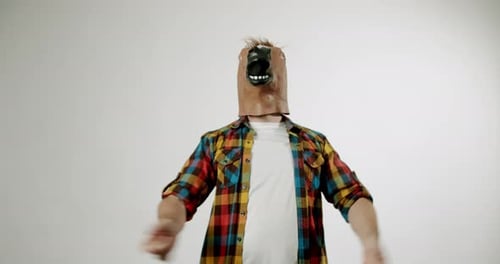 Man in Horse Mask Gesturing Against Plain Background