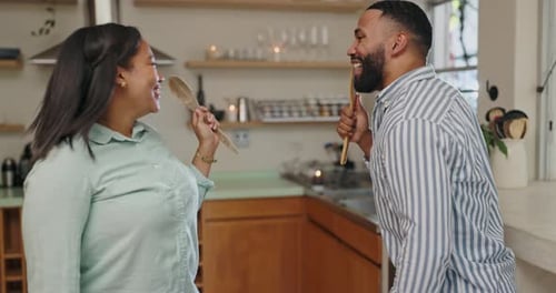 Couple Dancing and Singing with Spoons in Kitchen