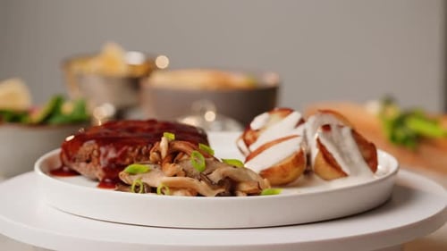 Close Up of Delicious Grilled Beef Steak Medallions Served on Table with Potato and Mushrooms and