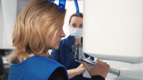 Zahnärztin macht Tomographie und Radiographie in einer modernen Zahnklinik, junge Patientin zu Besuch
